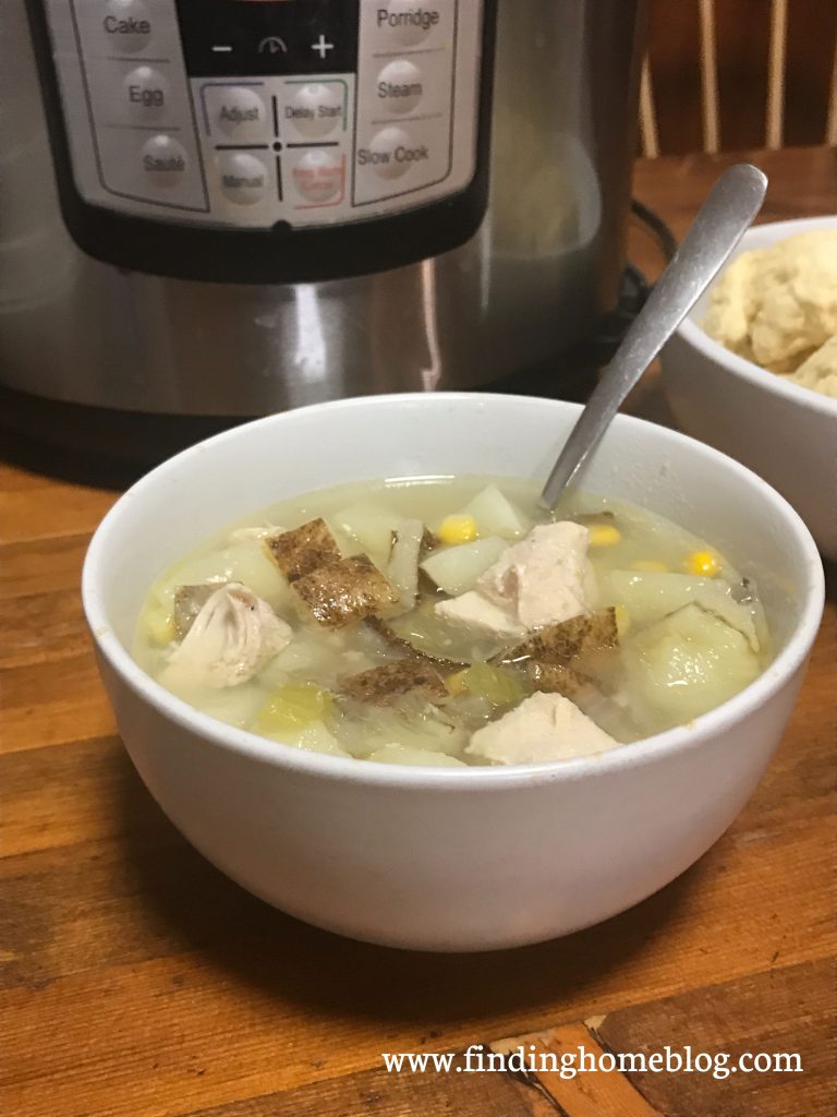 Close up of a bowl of soup with a spoon sticking out of it.