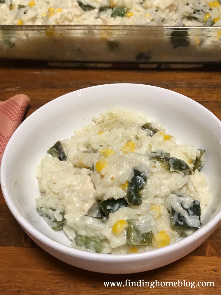 A rice based casserole with chicken, peppers, and corn in a bowl.