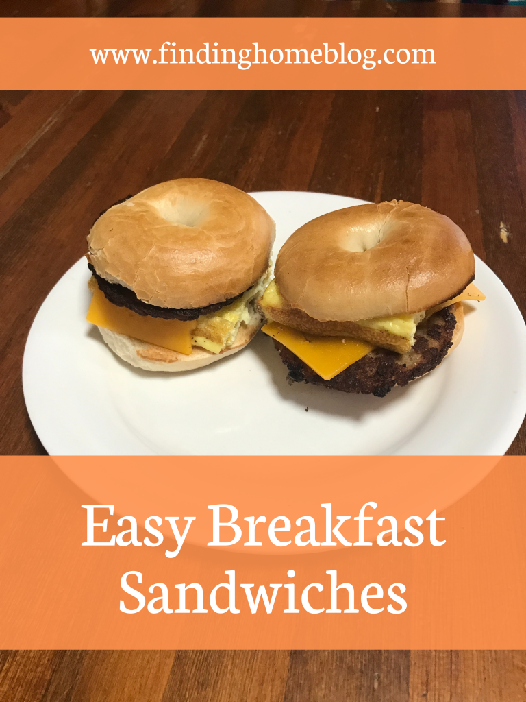 A plate with two breakfast sandwiches (bagel, egg, sausage patty, and cheese). A banner below reads "Easy Breakfast Sandwiches".